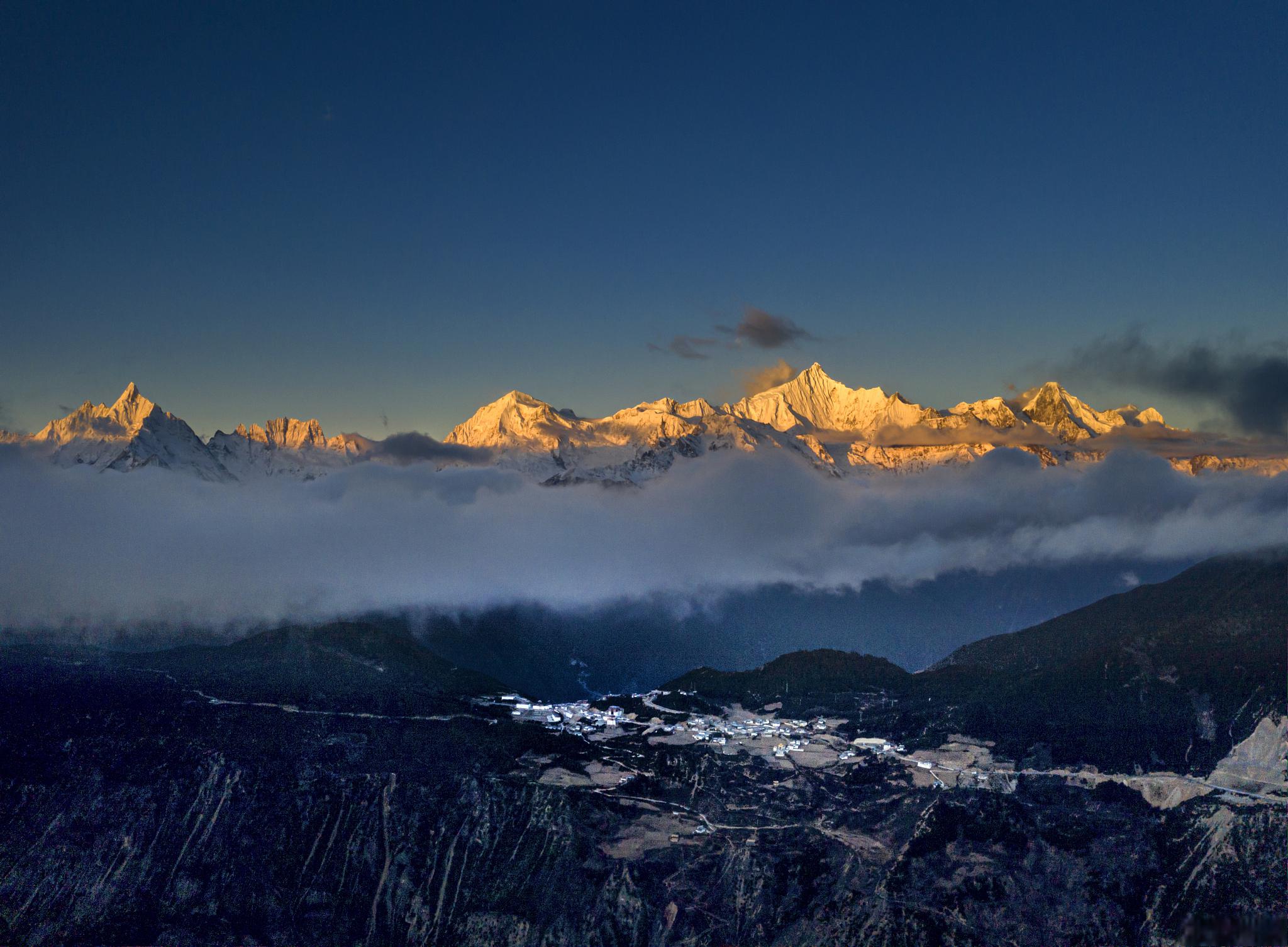 梅里雪山日照金山与月亮同框的浪漫景象 在遥远的西藏,有一座神秘而