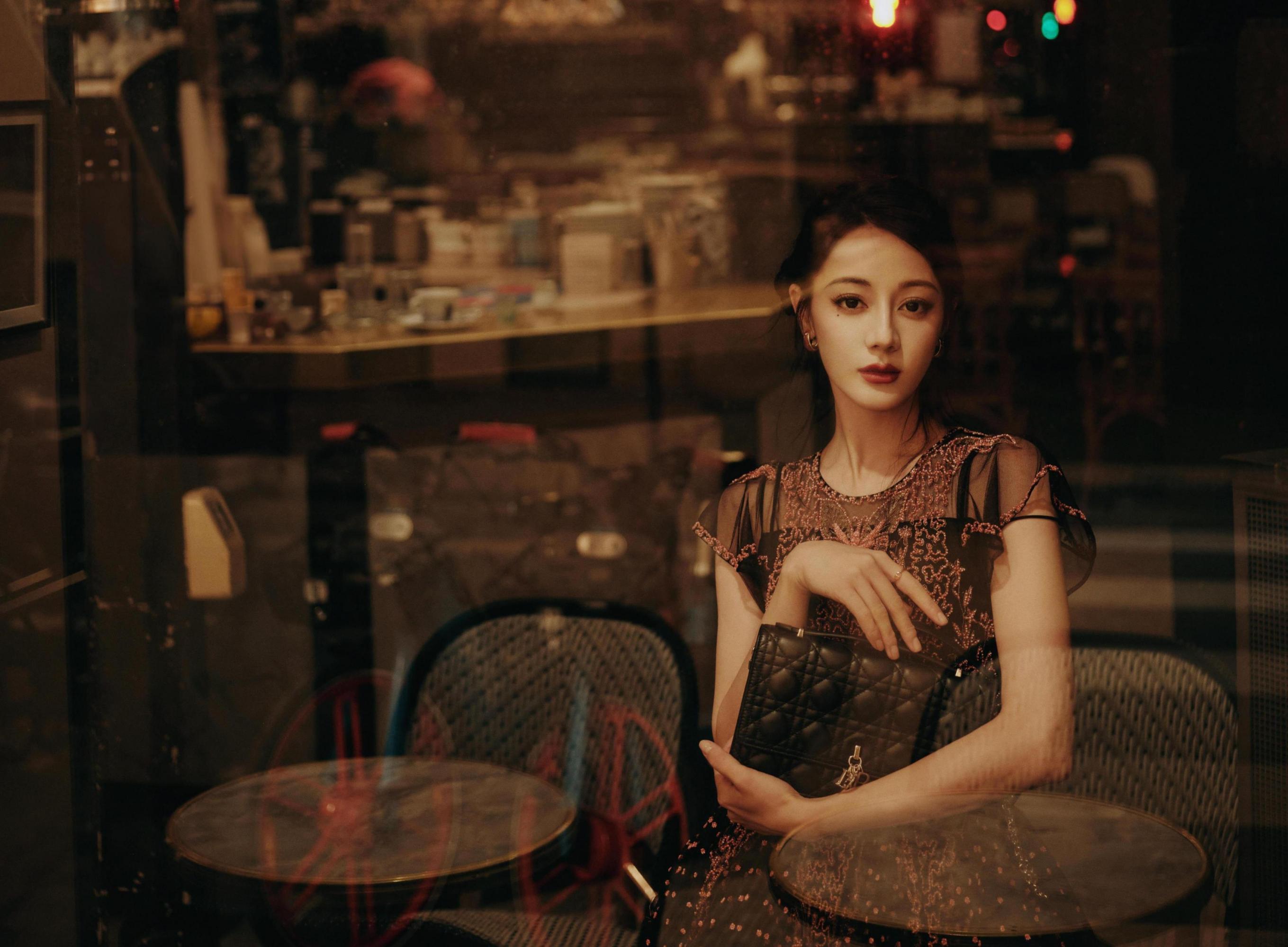 迪丽热巴黑色长裙灯下曼舞 迪丽热巴身着一袭黑色长裙,在灯光下翩翩