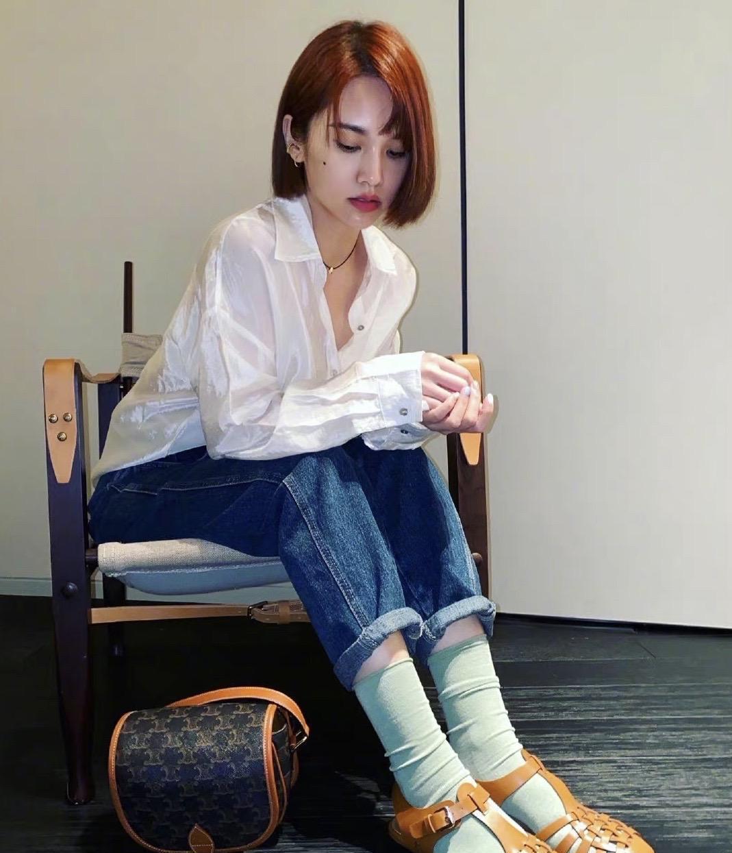 气质学院风 杨丞琳穿着一身校园风格,穿着白衬衣和牛仔短裤,脚上穿着