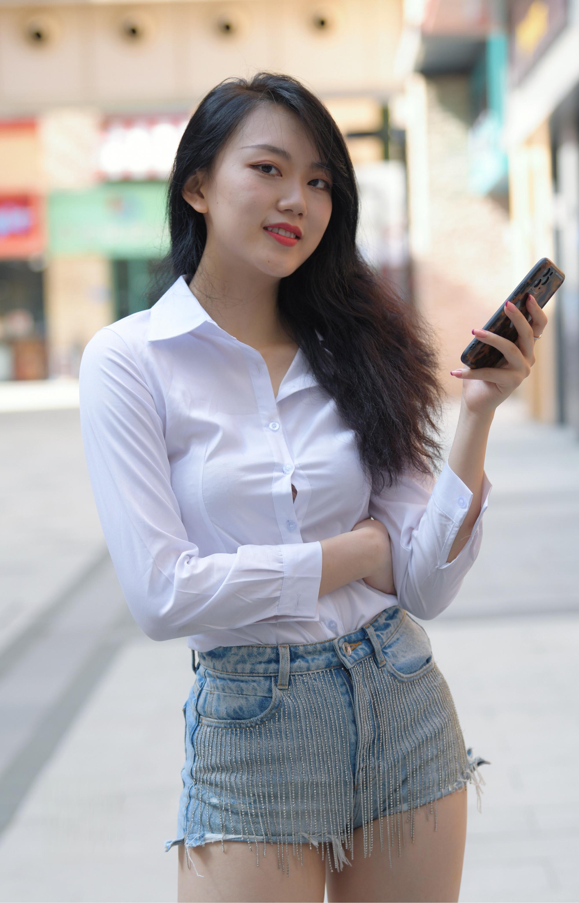 街拍达人:年轻黑发女子 今天的主角是一位年轻的黑发女子,穿着简约的