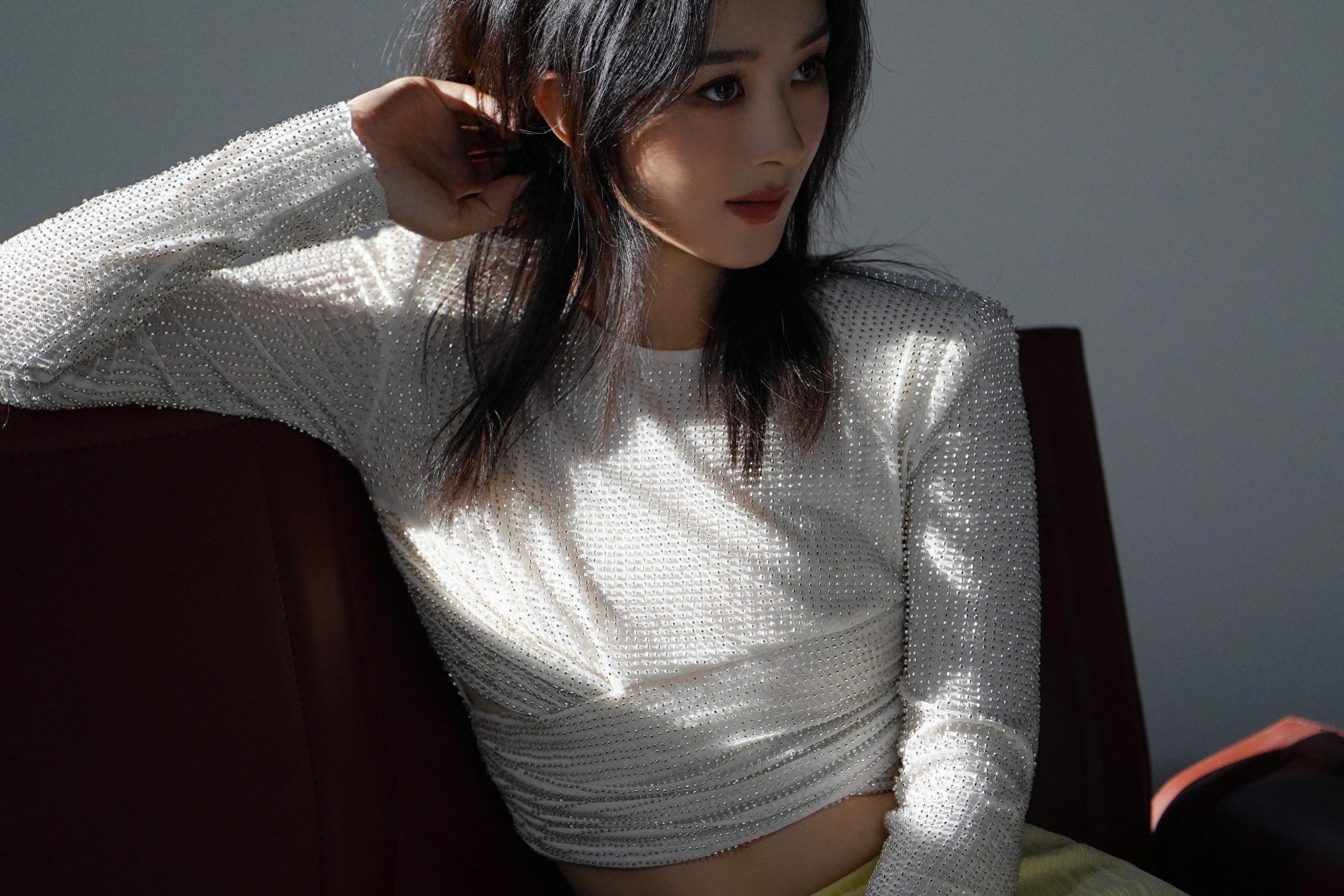 赵丽颖身着白色烫钻扭结上衣,搭配黄色针织半身鱼尾裙,脚穿银色一字带