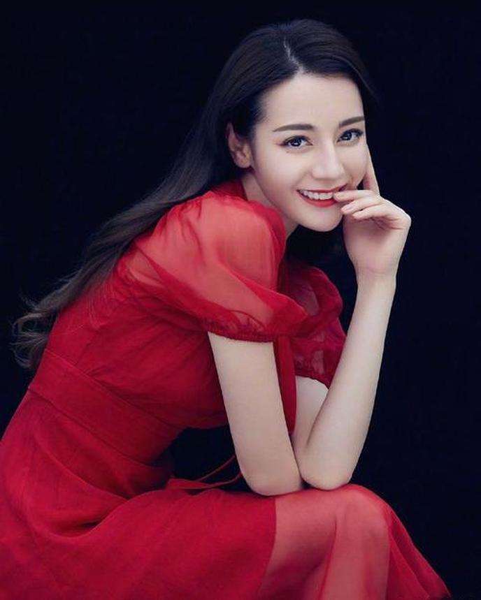 备受瞩目的女演员迪丽热巴以一头海藻般的长卷发搭配红色发箍的复古